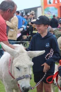 Pāuatahanui Lamb and Calf Day - boy with pet donkey